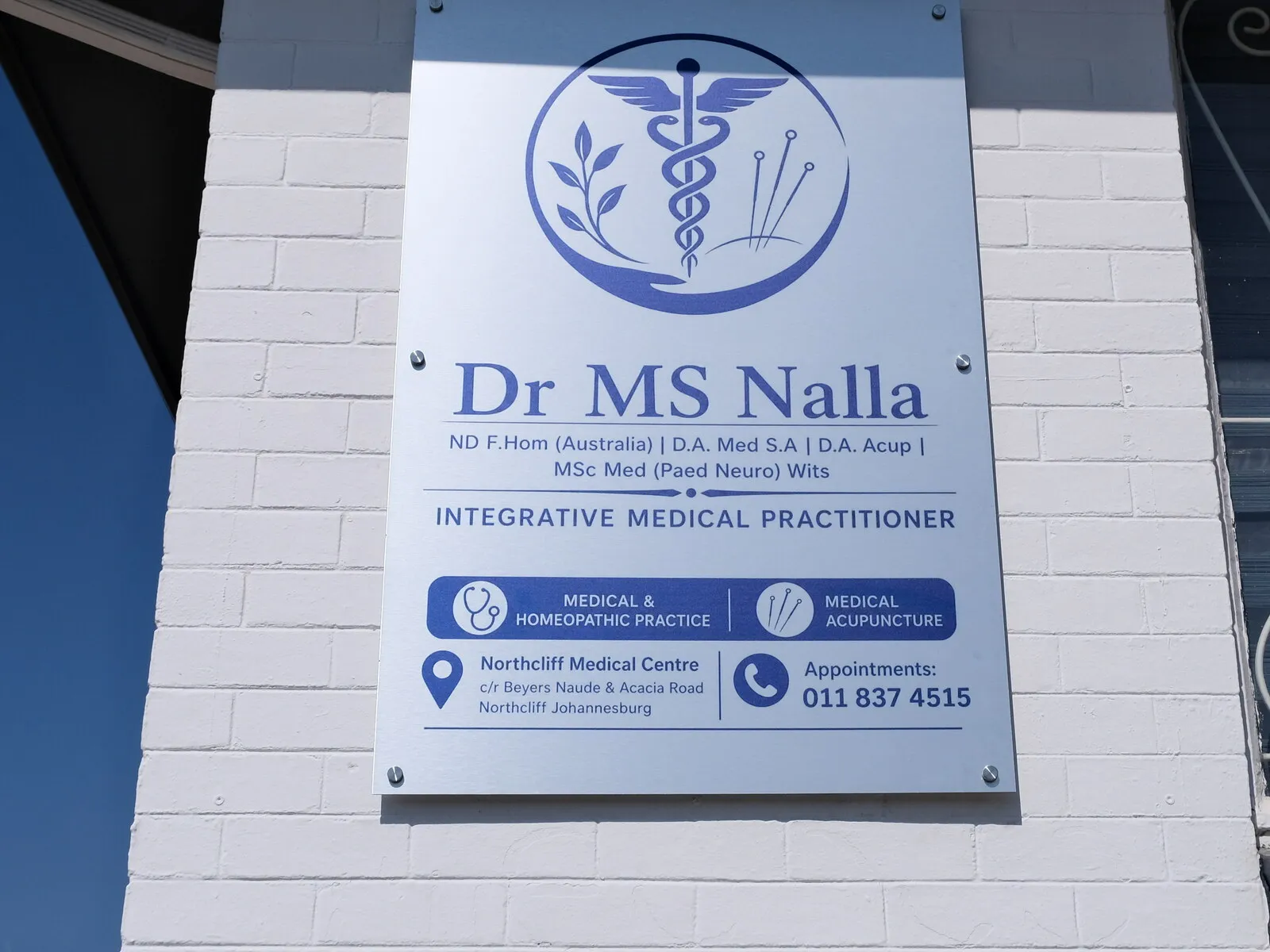 The practice board mounted outside the rooms, reading Dr MS Nalla, ND F.Hom (Australia), D.A. Med S.A, D.A. Acup, MSc Med (Paed Neuro) Wits, Integrative Medical Practitioner