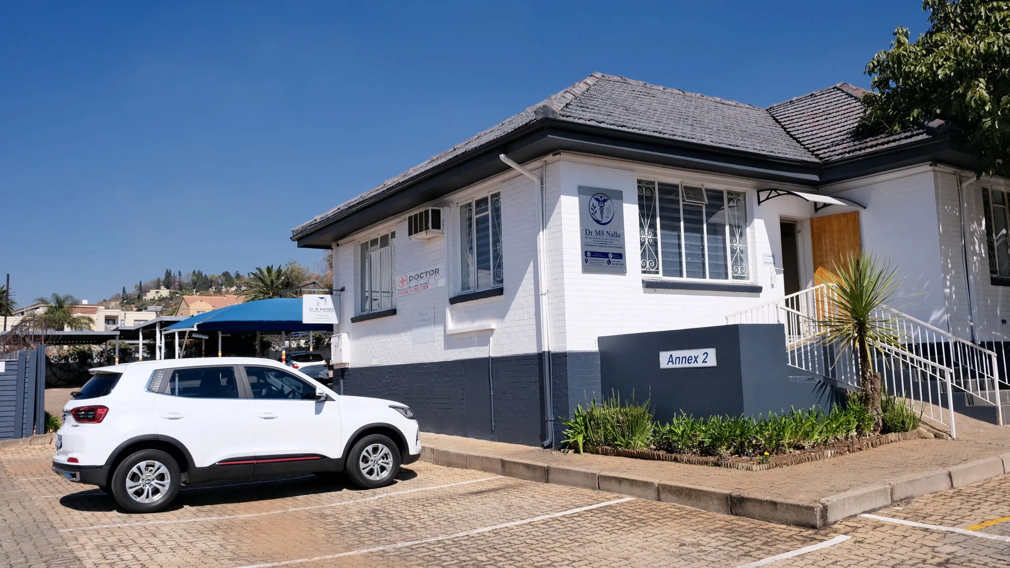 The white single storey building housing the practice, with Annex 2 painted on the low wall beside the parking bays